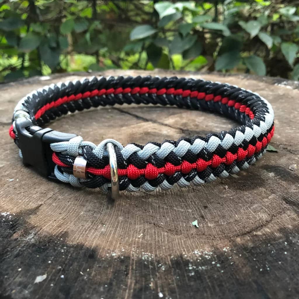 black white and red heavy duty collar placed on a wooden surface